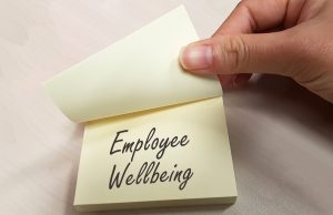 Post-it note with the words Employee Wellbeing written on it